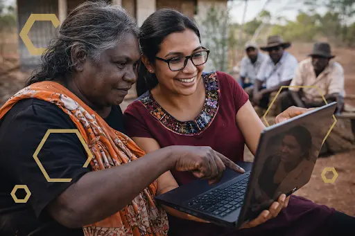 two rural women looking into a laptop