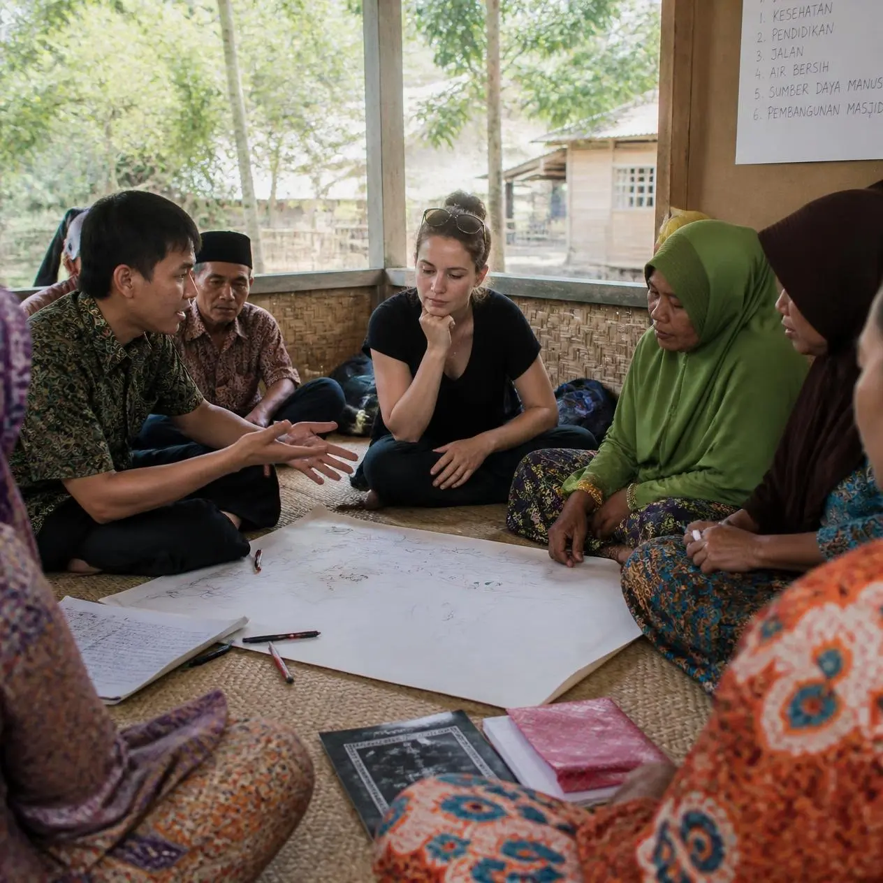 Local and international researchers collaborate with community members, illustrating localization, shared decision-making, and context-sensitive ethical research.